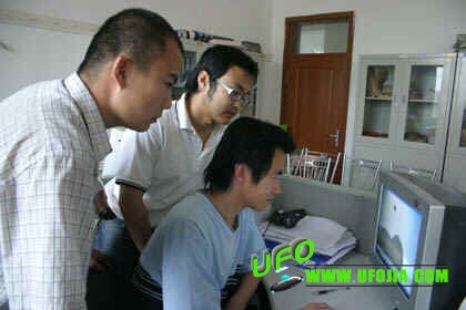 张·希仁巴雅和韩巍与辅导员丘志武将珍贵的图像存储在电脑中